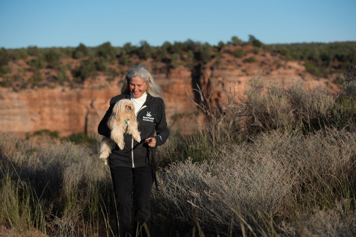 Jana de Peyer holding a small white dog in Angel Canyon